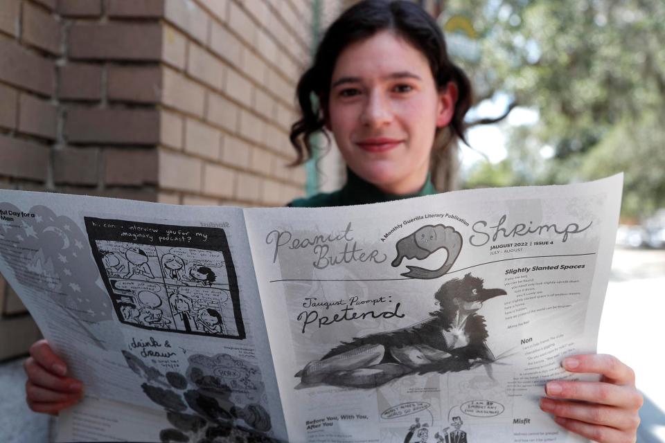 Carly Lieberman with copies of her Peanut Butter Shrimp newspaper.