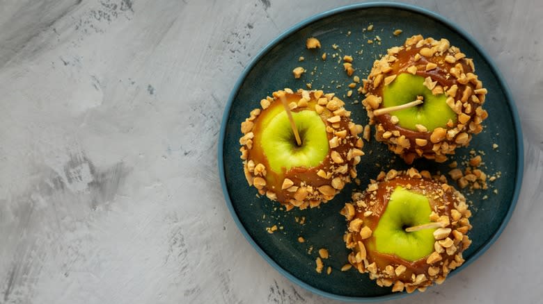 Caramel apples with nuts on plate