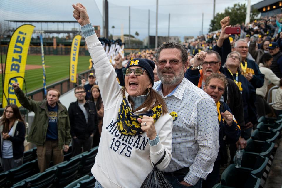 U-M alumnus Linda Lockwood (Class of 1980) next to her husband Stacy Horton, both of Traverse City, cheer on as the Michigan Marching Band perform during a Fiesta Bowl pep rally at Scottsdale Stadium in Scottsdale on Dec. 30, 2022.