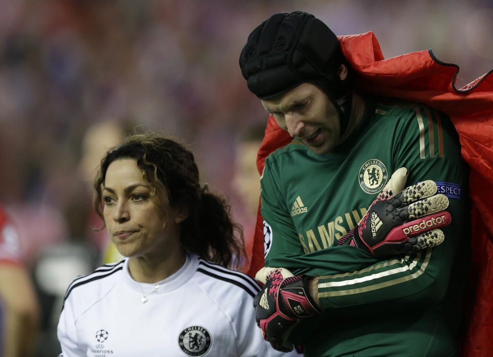 Chelsea goalkeeper Petr Cech holds his arm as he is covered by a blanket as he leaves the pitch following an injury during the Champions League semifinal first leg soccer match between Atletico Madrid and Chelsea at the Vicente Calderon stadium in Madrid, Spain, Tuesday, April 22, 2014 .(AP Photo/Paul White)