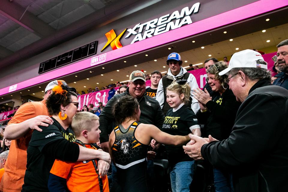 Charles City's Lilly Luft, back to camera, visits with Ember Henderson after winning the 130-pound state championship Friday at Xtream Arena in Coralville. Henderson, of Louisville, Ky., was the recipient of Logan Luft’s heart after he died in an ATV accident in 2017.