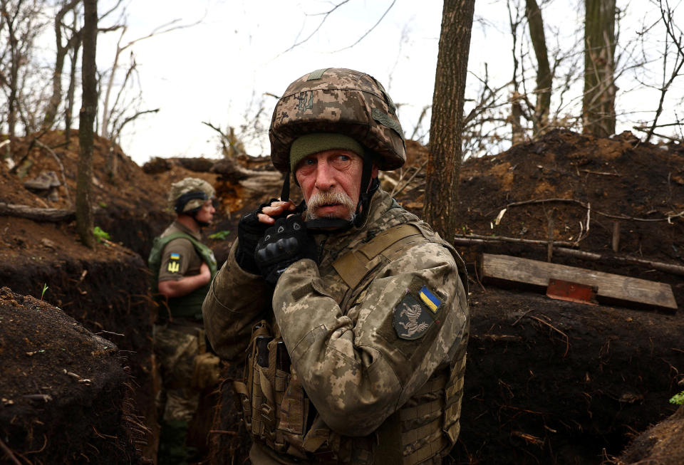 A Ukrainian serviceman adjusts his helmet in a trench during incoming artillery shelling on the frontline in Ukraine on Saturday, April 8.  