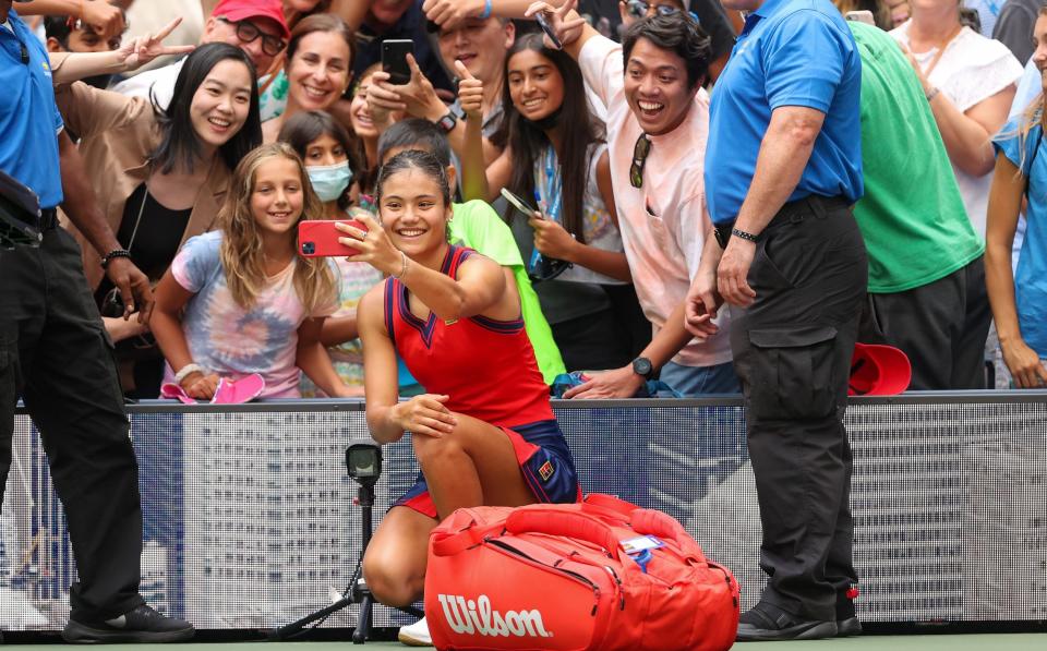 Emma Raducanu takes selfies with fans after beating Shelby Rogers in 2021