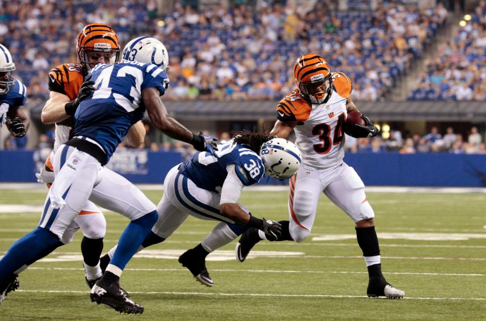 Bengals running back Dan Herron tries to get past Colts defensive back Mike Newton in 2012.