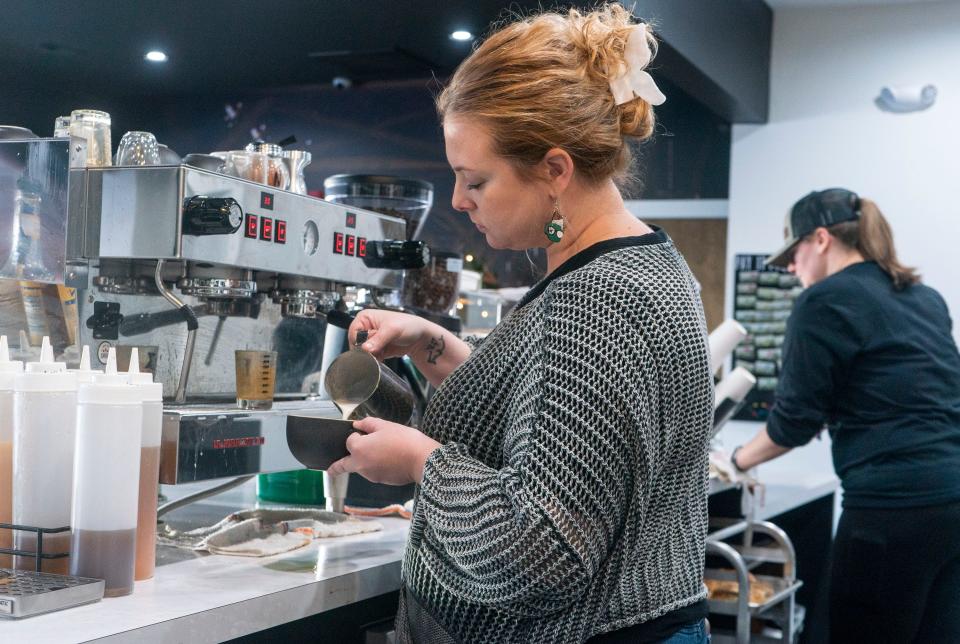 Manager, Andrea Newton, left, pours milk into a latte while Brittany Tomes, right, cleans up at the Bridge Coffee & Community in Levittown on Thursday, Nov. 30, 2023.

[Daniella Heminghaus | Bucks County Courier Times]