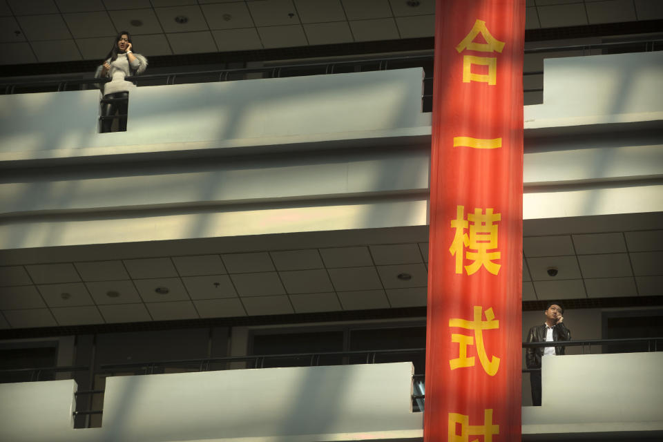 In this Friday, Feb. 24, 2017 photo, people talk on their cellphones at Haier's headquarters in Qingdao in eastern China's Shandong Province. Zhang Ruimin built Haier from a failing refrigerator factory in the 1980s into the biggest maker of major appliances. Now, he is trying to transform a traditional manufacturer with 60,000 employees in 25 countries into a nimble, Internet Age seller of consumer goods and services from web-linked washing machines to food delivery. (AP Photo/Mark Schiefelbein)