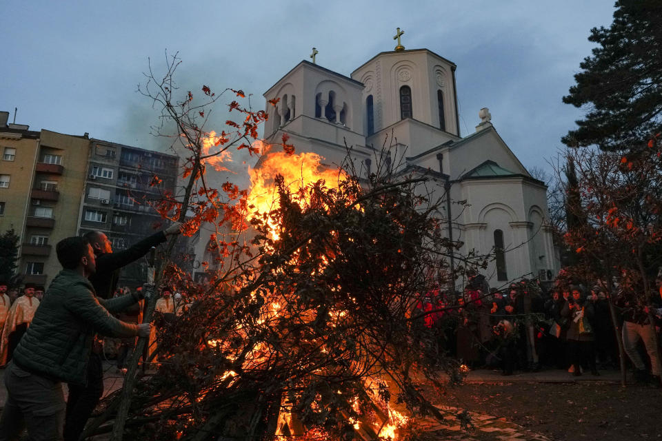 People burn dried oak branches, the Yule log symbol for the Orthodox Christmas Eve, in front of St. Sava church in Belgrade, Serbia, Saturday, Jan. 6, 2024. Orthodox believers in Serbia celebrate Christmas on Jan. 7, according to the Julian calendar. (AP Photo/Darko Vojinovic)