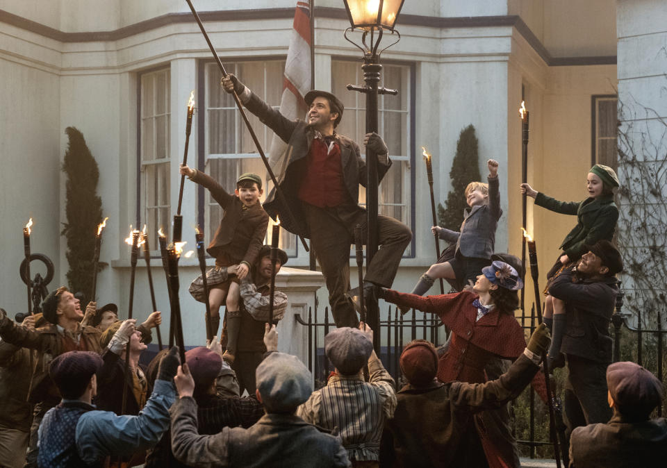 Lin-Manuel Miranda, centro, y Emily Blunt en una escena de "Mary Poppins Returns" en una imagen proporcionada por Dinsey. (Jay Maidment/Disney via AP)