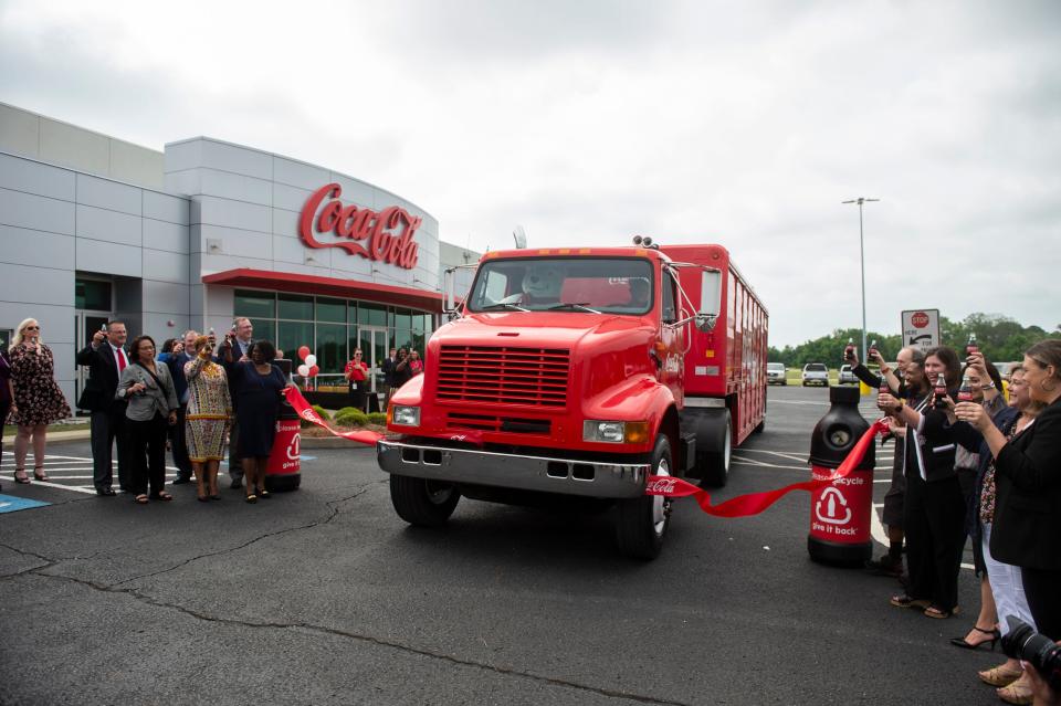 The ribbon is broken as Coca-Cola United donates trucks to Trenholm State Community College for driving classes in Montgomery, Ala., on Tuesday, May 9, 2023.