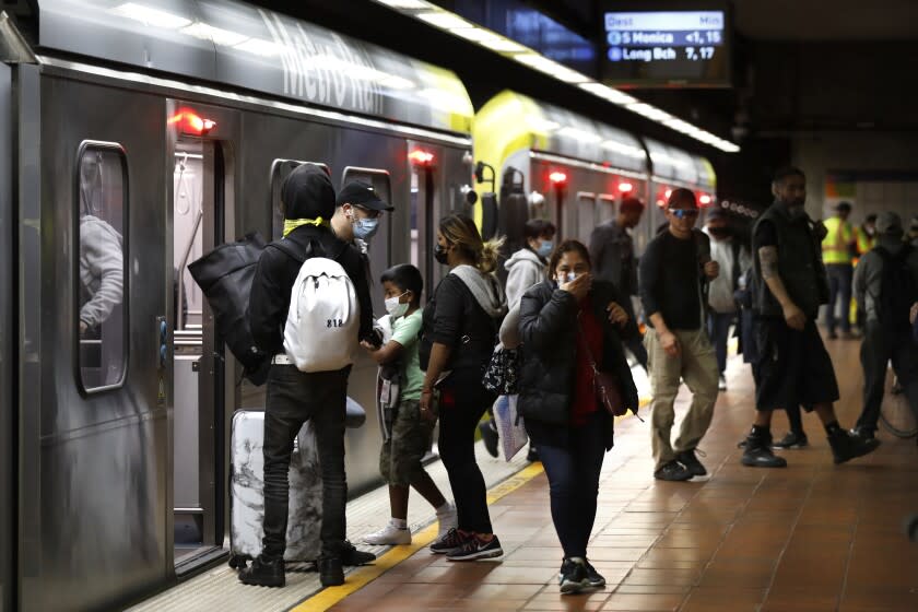 Los Angeles, California-March 10, 2022- Riders of Los Angeles Metro wait at the station at Figueroa and 7th St. in downtown, Los Angeles on March 10, 2022. As gas reaches record highs, some turn to mass transit. But it's not an easy sell. Transportation is the second highest expense for American families after housing. At $1.75 a ride, Metro train and bus fare is a bargain. (Carolyn Cole / Los Angeles Times)