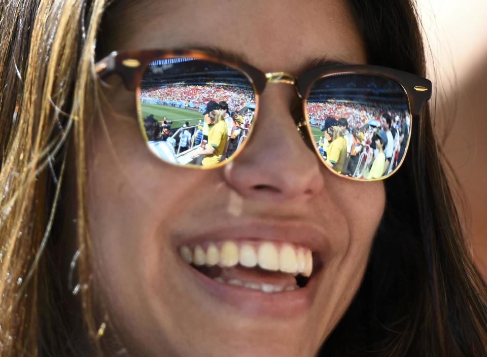 A partial view of the stadium and its spectators are seen reflected in a fan's sunglasses as she waits for the start of the 2014 World Cup quarter-finals between Argentina and Belgium at the Brasilia national stadium in Brasilia July 5, 2014. REUTERS/Dylan Martinez