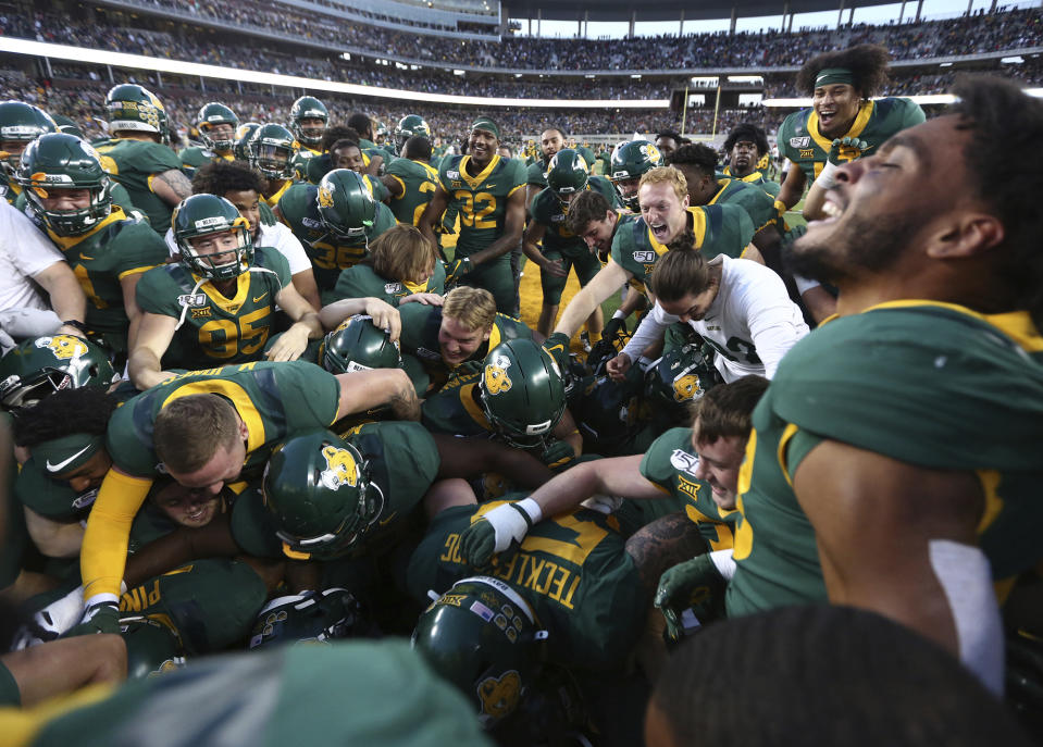 Baylor players mob Baylor running back JaMycal Hasty after his game winning touchdown in overtime against Texas Tech after a NCAA college football game, Saturday, Oct. 12, 2019, in Waco, Texas. Baylor won 33-30. (Rod Aydelotte/Waco Tribune Herald via AP)