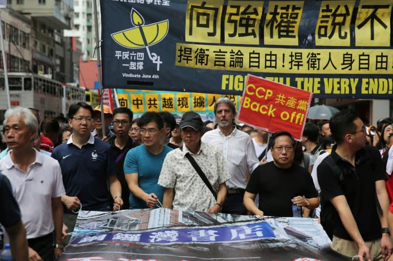 Lam Wing-kee (C-in cap), defied Beijing by speaking out about his detention and leading a protest in Hong Kong on June 18, 2016, as pressure grows for authorities to answer questions over his case