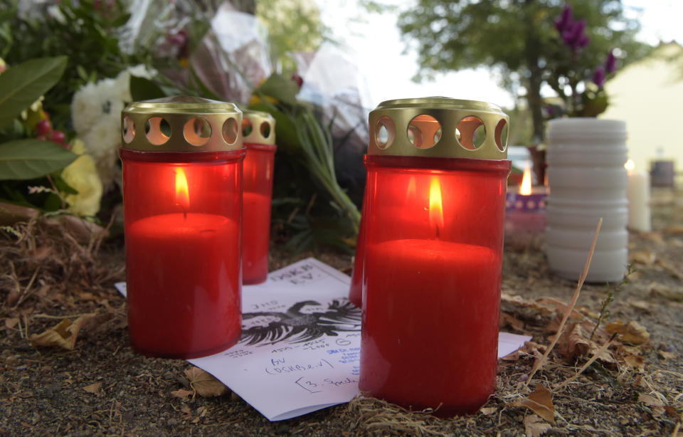 Candles burn at the site of a deadly brawl in Koethen, 90 miles southwest of the German capital Berlin, Sunday, Sept. 9, 2018. Police has arrested two Afghan men on suspicion of murder in the killing of a 22-year-old German man. (AP Photo/Jens Meyer)
