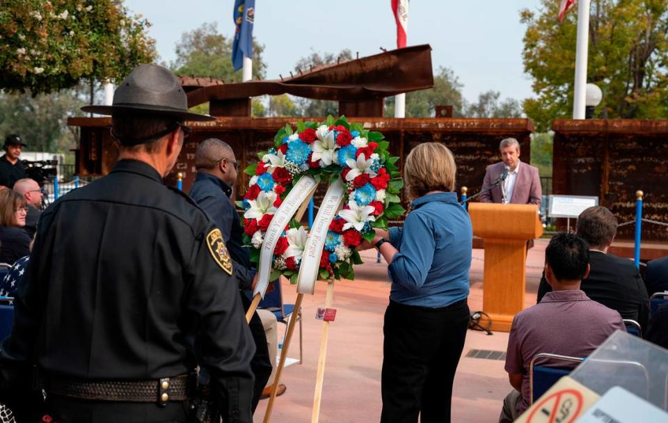 Veteran Tim Young and veteran spouse Dana Almora, both of Pride Industries, carry the memorial wreath forward followed by Cal Expo police chief Craig Walton during the ceremony on Sept. 11, 2022, remembering the events of 9/11 at Cal Expo’s September 11 Memorial Plaza.