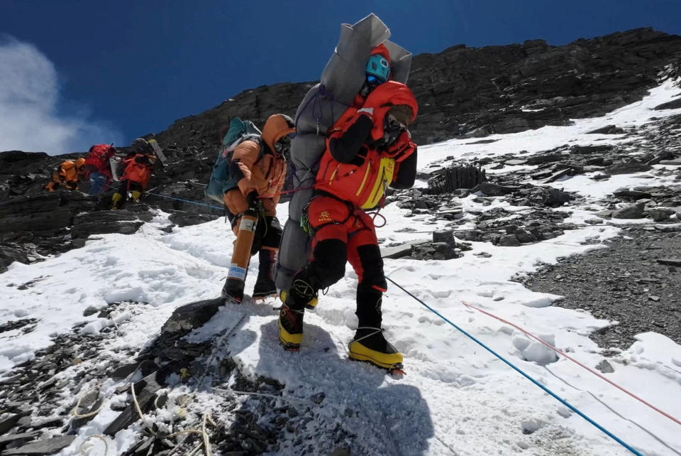 Der Sherpa Ngima Tashi trägt einen Bergsteiger aus Malaysia auf seinem Rücken aus der 