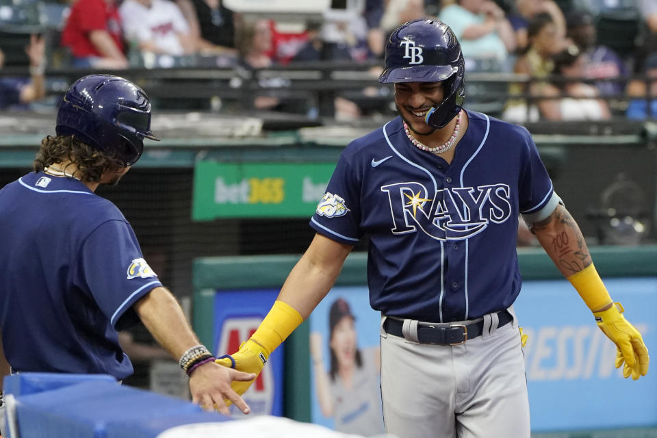 Tampa Bay Rays' Jose Siri, right, is congratulated as he returns to the dugout after hitting a home run in the sixth inning of a baseball game against the Cleveland Guardians, Saturday, Sept. 2, 2023, in Cleveland. (AP Photo/Sue Ogrocki)