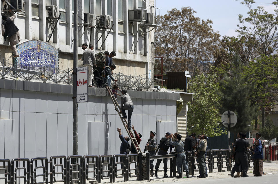 Afghan security personnel rescue men and children from the information and culture ministry after an attack near to the Telecommunication Ministry in Kabul, Afghanistan, Saturday, April 20, 2019. Afghan officials say an explosion has rocked the telecommunications ministry in the capital city of Kabul. Nasart Rahimi, a spokesman for the interior ministry, said Saturday the blast occurred during a shootout with security forces. (AP Photo/Rahmat Gul)