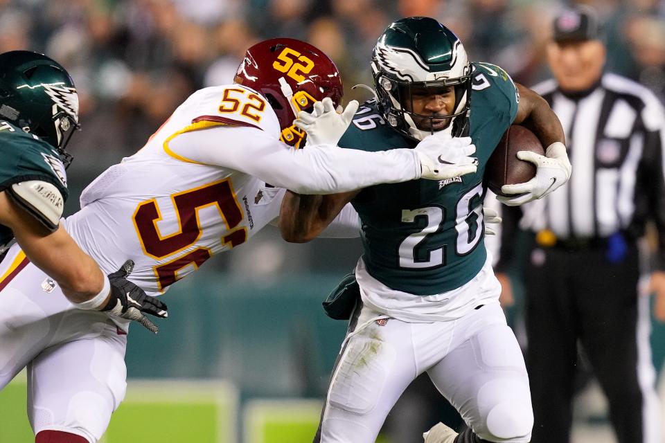 The Philadelphia Eagles' Miles Sanders carries the ball as Jamin Davis of the Washington Football Team defends.