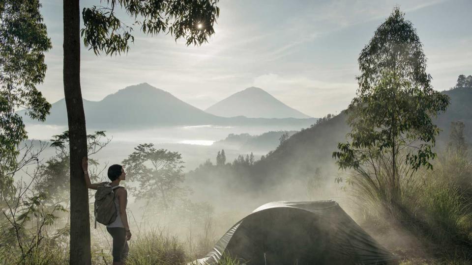 looking at the view while camping on Kintamani ridge, in front of Mount Agung volcano, at sunrise in Bali