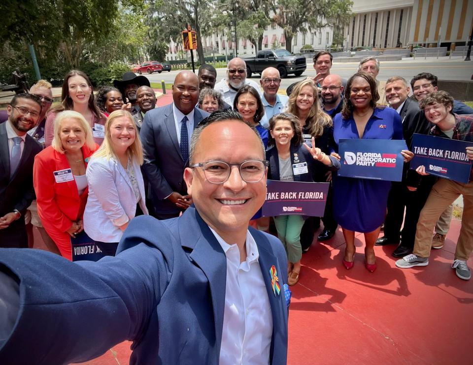 Newly-elected Sen. Carlos Guillermo Smith, D-Orlando, takes a selfie with a dozen first time legislative candidates and Democratic National Committee chair Jaime Harrison in Tallahassee at a press availability.