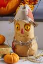 <p>We promise this sweet fella, made out of a butternut squash, won't scare away any Halloween party guests.<strong><br></strong></p><p><strong>Make the Scarecrow Pumpkin:</strong> Use a melon baller to scoop out two eyes from a butternut squash; reserve. Etch out eye sockets and mouth with a linoleum cutter. Use toothpicks to secure eyes in sockets. Push in dried black bean pupils; secure with toothpicks. Cut a piece of red masking tape and attach for nose. For hat, make a cone from a paper bag, then fold in its top and fringe its bottom, curling upward. Cut patches from burlap and attach with small masking tape strips. Tie cord ribbon around middle for a belt and tuck in straw.</p>