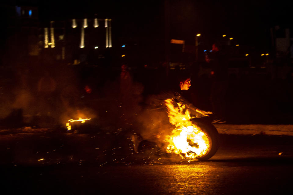 Protesters burn tires to close a main road, at Martyrs Square, in downtown Beirut, Lebanon, Saturday, March 6, 2021. Lebanon's caretaker prime minister warned Saturday that the country was quickly headed toward chaos and appealed to politicians to put aside differences in order form a new government that can attract desperately needed foreign assistance. (AP Photo/Hassan Ammar)