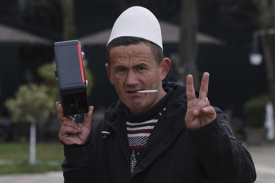 A man wearing a traditional Albanian hat poses for a picture in Kukes city, 150 kilometers (90 miles) northern of Tirana, Albania, Wednesday, March 15, 2023. Thousands of young Albanians have crossed the English Channel in recent years to seek a new life in the U.K. Their dangerous journey in small boats or inflatable dinghies reflects Albania's anemic economy and a younger generation’s longing for fresh opportunities. (AP Photo/Franc Zhurda)