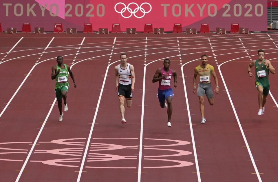 Erriyon Knighton, center, races to win a men's 200-meter heat at the Tokyo Olympics in August.