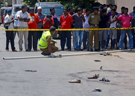 A crime scene officer inspects the site of a shooting at an election rally in Colombo July 31, 2015. REUTERS/Stringer