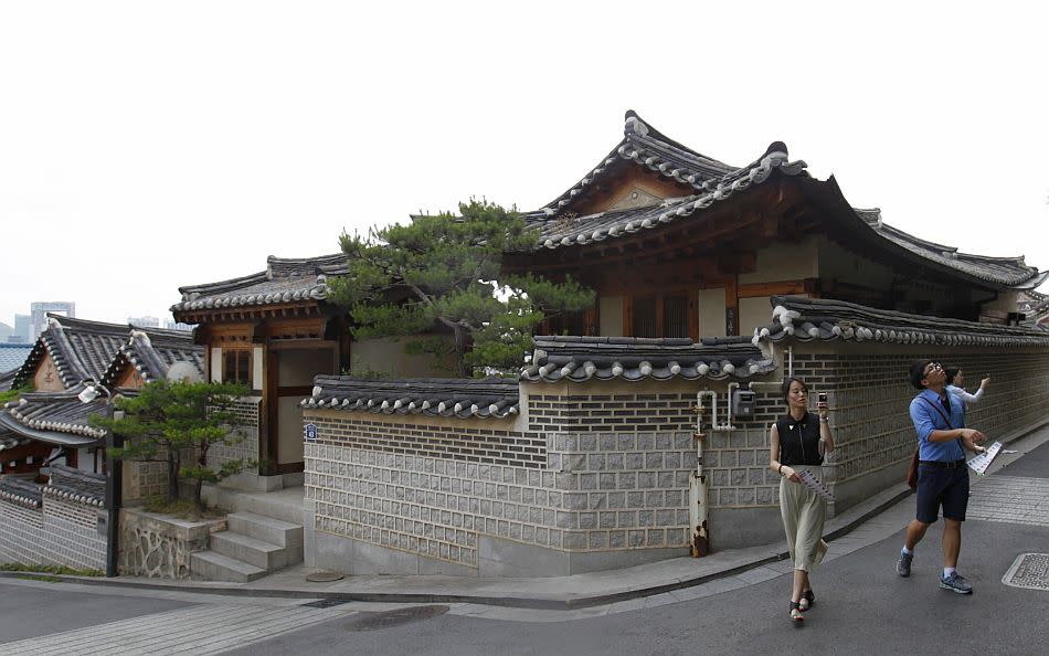 People take pictures at Bukchon Hanok Village, a traditional village in Seoul