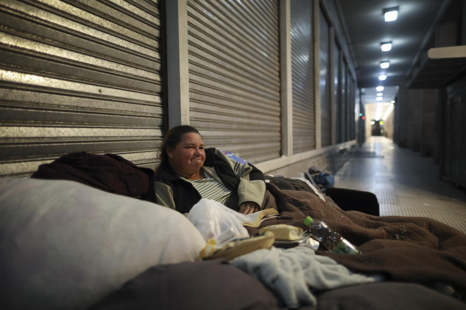 A homeless woman sits on a mattress on a sidewalk during a government-ordered lockdown to curb the spread of the new coronavirus in Buenos Aires, Argentina, Tuesday, July 7, 2020. (AP Photo/Natacha Pisarenko)