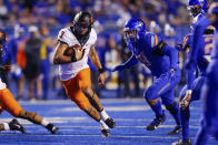 Oklahoma State quarterback Spencer Sanders (3) runs with the ball past Boise State defensive end Demitri Washington (38) during the first half of an NCAA college football game Saturday, Sept. 18, 2021, in Boise, Idaho. (AP Photo/Steve Conner)