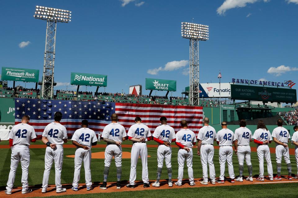 The Boston Red Sox line up on the first-base line wearing No. 42 in honor of Jackie Robinson before Friday's home opener against the Minnesota Twins.