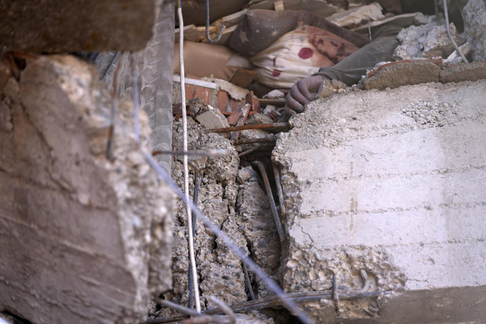 The hand of a dead child is seen among rubbles of a destroyed building, in Kahramanmaras, southern Turkey, Wednesday, Feb. 8, 2023. Nearly two days after the magnitude 7.8 quake struck southeastern Turkey and northern Syria, thinly stretched rescue teams work to pull more people from the rubble of thousands of buildings. (AP Photo/Hussein Malla)