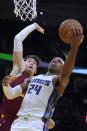 Sacramento Kings' Buddy Hield (24) drives to the basket against Cleveland Cavaliers' Cedi Osman (16) during the second half of an NBA basketball game, Saturday, Dec. 11, 2021, in Cleveland. (AP Photo/Tony Dejak)