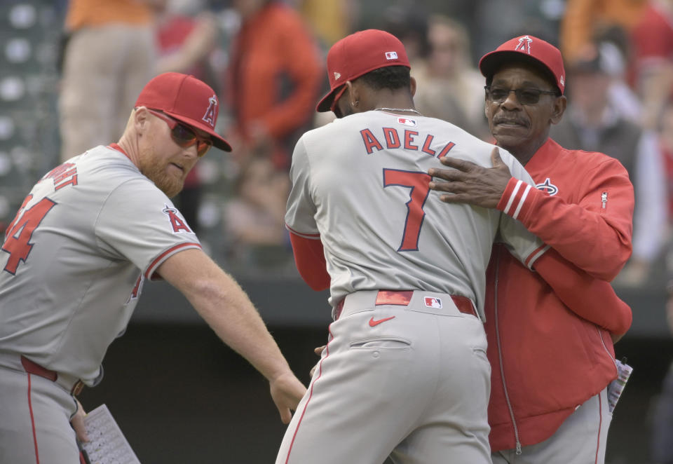 Los Angeles Angels manager Ron Washington, right, and pitching coach Barry Enright, left, celebrate with outfielder Jo Adell after beating the Baltimore Orioles in a baseball game, Sunday, March 31, 2024, in Baltimore. (AP Photo/Steve Ruark)