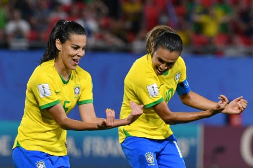 Marta (right) celebrates her record-breaking goal with midfielder Thaisa