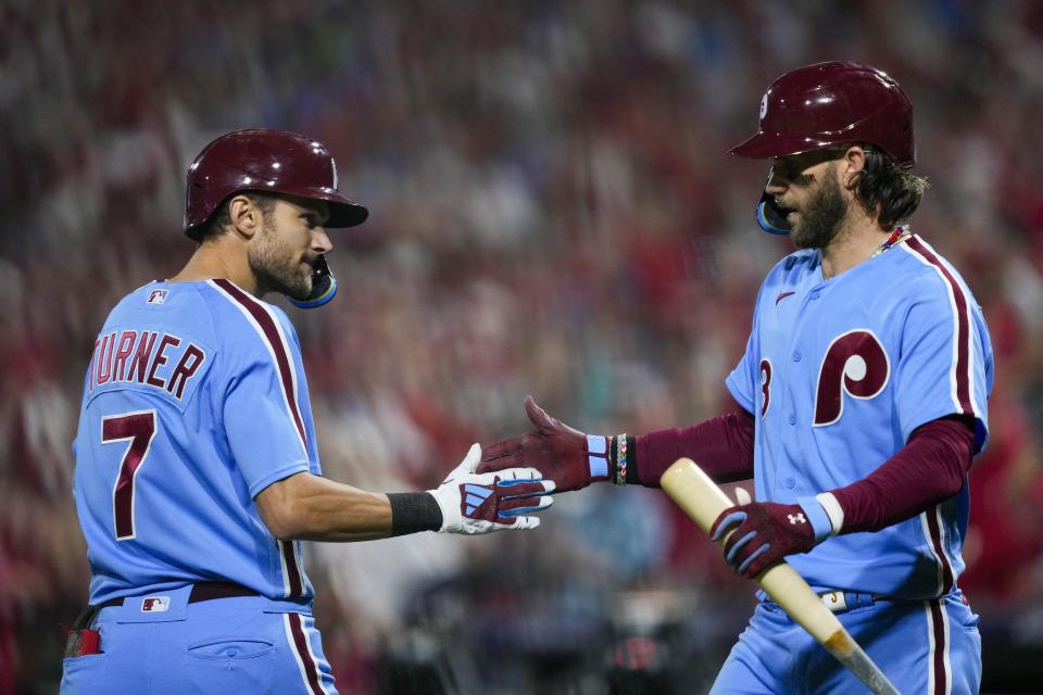 Philadelphia Phillies' Trea Turner is congratulated by Bryce Harper after hitting a home run during the fifth inning of Game 4 of a baseball NL Division Series against the Atlanta Braves Thursday, Oct. 12, 2023, in Philadelphia. (AP Photo/Matt Rourke)