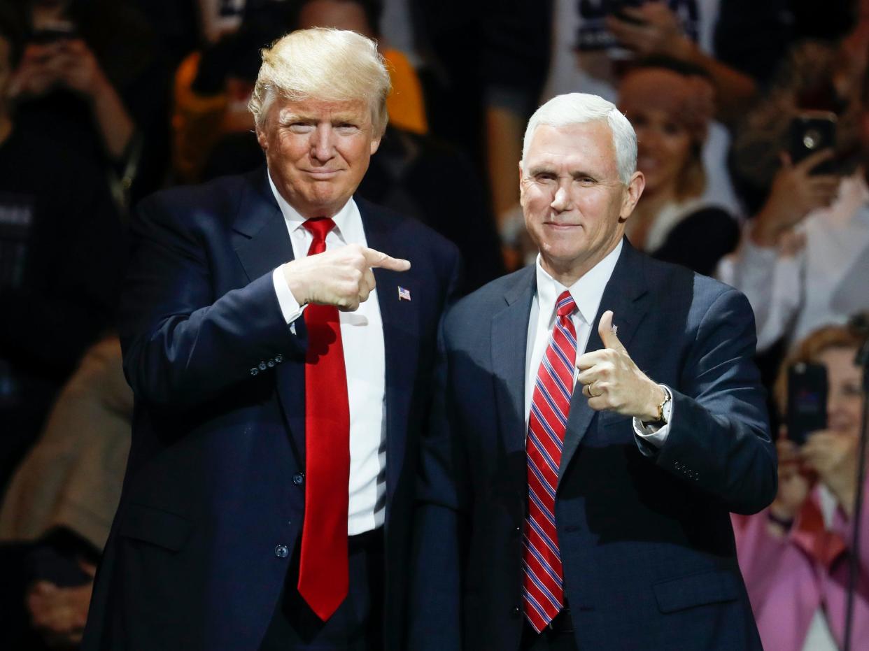 Former President elect Donald Trump, left, and former Vice President Mike Pence acknowledge the crowd during the first stop of his post-election tour, in Cincinnati on December 1, 2016.