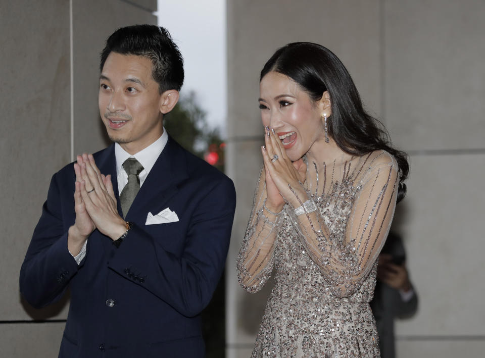 Daughter of former Thai Prime Minister Thaksin Shinawatra, Pintongtha "Aim", right, and her husband Nattapong "Pong" Kunakornwong welcome guests at the wedding of Thaksin's youngest daughter Paetongtarn "Ing" Shinawatra at a hotel in Hong Kong, Friday, March 22, 2019. (AP Photo/Kin Cheung)