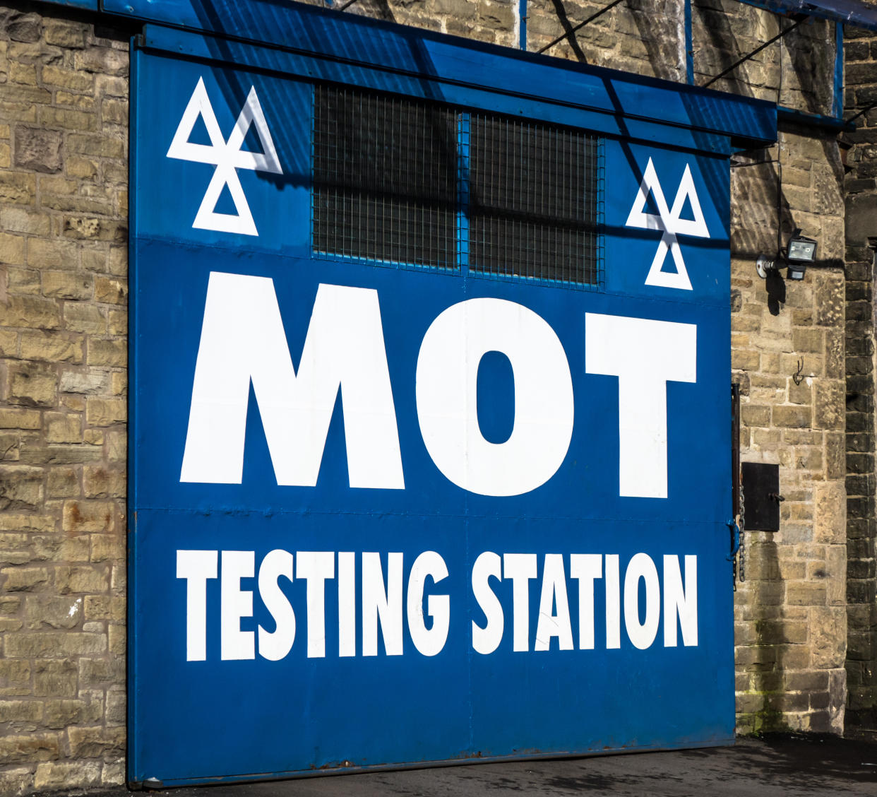 Large sign on the doorway of an MOT testing station in the UK.