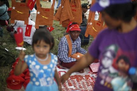 A man sells merchandise with the National League for Democracy party (NLD) logo before Myanmar pro-democracy leader Aung San Suu Kyi's speech during her campaign for the upcoming general election, in Demoso, Kayah state September 10, 2015. REUTERS/Soe Zeya Tun