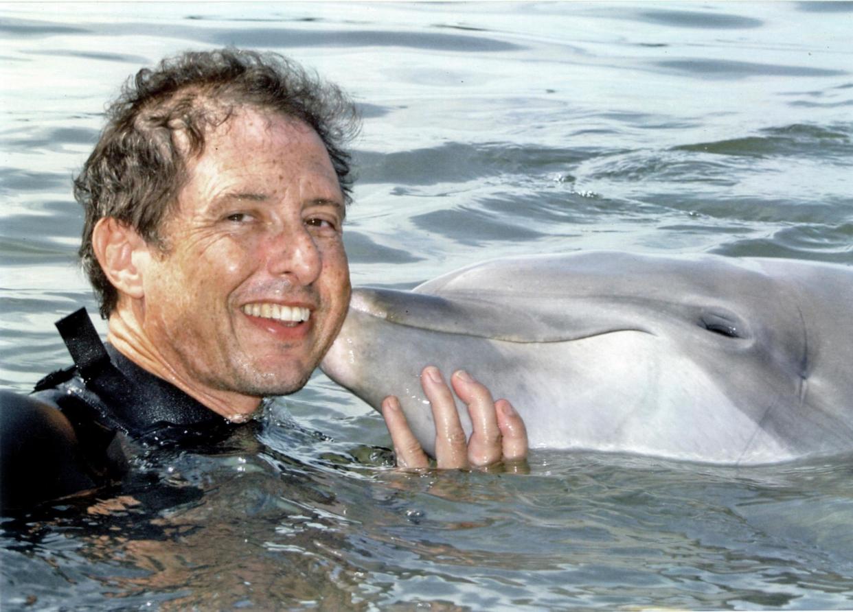 Malcolm Brenner with an unidentified dolphin. (Photo: Malcolm Brenner)