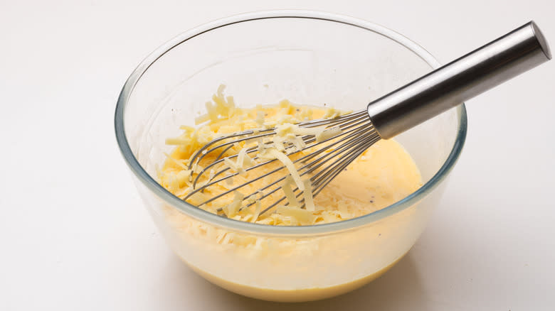 mixing cheddar into whisked eggs