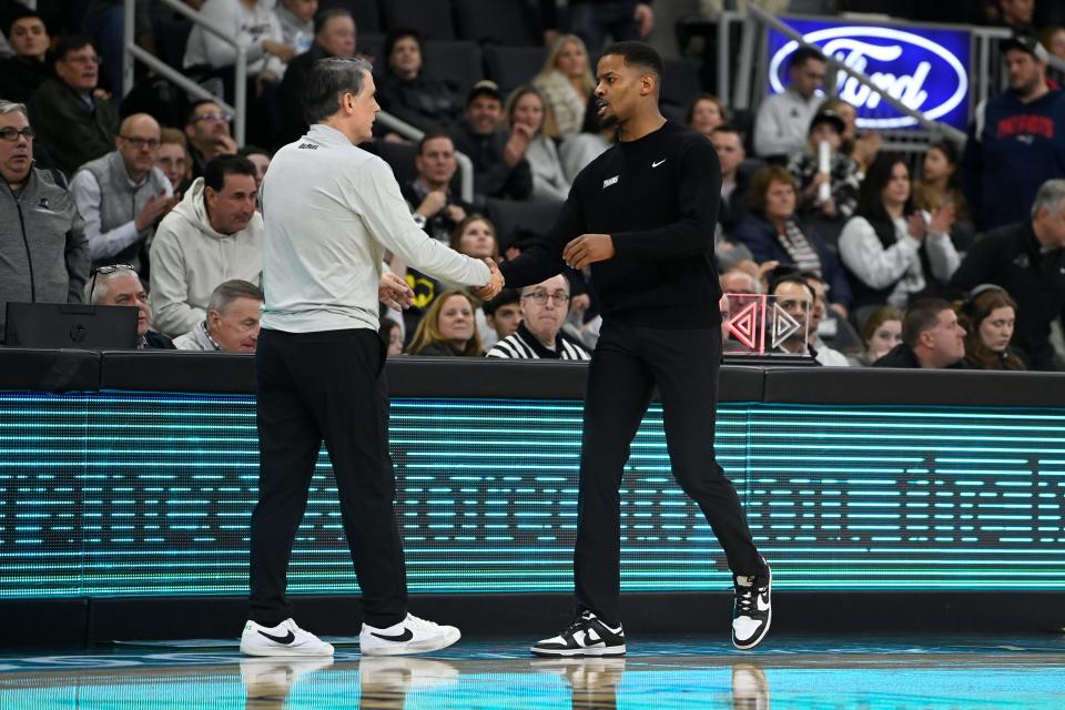 Providence College men's basketball head coach Kim English, right, shakes hands with DePaul head coach Tony Stubblefield after Saturday's game.