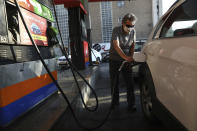 A man fills his car at a gas station in Tehran, Iran Wednesday, Oct. 27, 2021. Iran's President Ebrahim Raisi said Wednesday that a cyberattack which paralyzed every gas station in the Islamic Republic was designed to get "people angry by creating disorder and disruption." Long lines snaked around the pumps a day after the incident began as some stations began selling fuel again although at higher, unsubsidized prices. (AP Photo/Vahid Salemi)