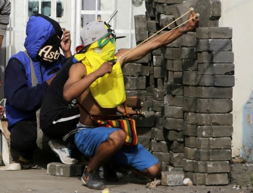 An anti-government demonstrator uses a slingshot during clashes with riot police at a barricade in the town of Masaya, 35 km from Managua on June 9, 2018