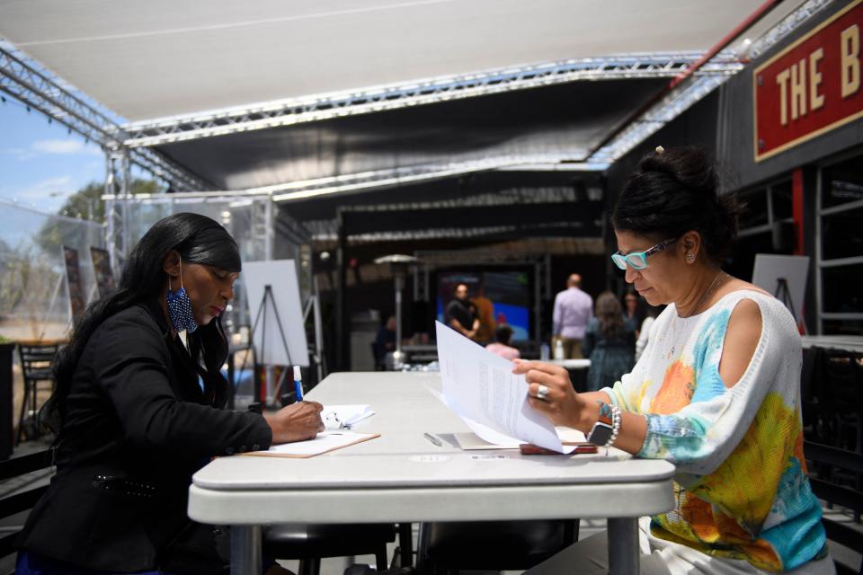 Sandra Presley (L) interviews for a job as a hotel front desk staff member with a human resources manager during a Zislis Group job fair at The Brew Hall on June 23, 2021 in Torrance, California. - Employers at the job fair for Zislis Group boutique hotel and restaurant management company, offered hiring incentives, including a $500 signing bonus and $200 per month for medical benefits after 90 days of employment. (Photo by Patrick T. FALLON / AFP) (Photo by PATRICK T. FALLON/AFP via Getty Images)