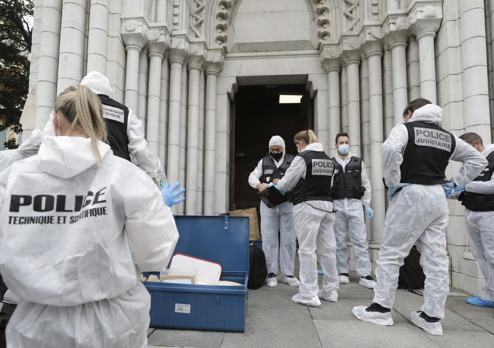 FILE - In this Oct.29, 2020 file photo, forensic police officers inspect the scene of a knife attack at Notre Dame church in Nice, southern France. French lawmakers tackle a bill on Monday to dig up radical Islam by its roots in the country, beliefs that authorities maintain are creeping into public services, associations, some schools and online with the goal of undermining national values. (Eric Gaillard/Pool via AP, File)